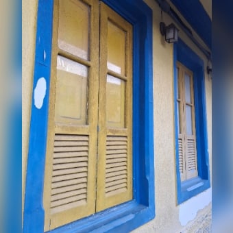 Publicação no Instagram: janela antiga com venezianas amarelas e batente azul